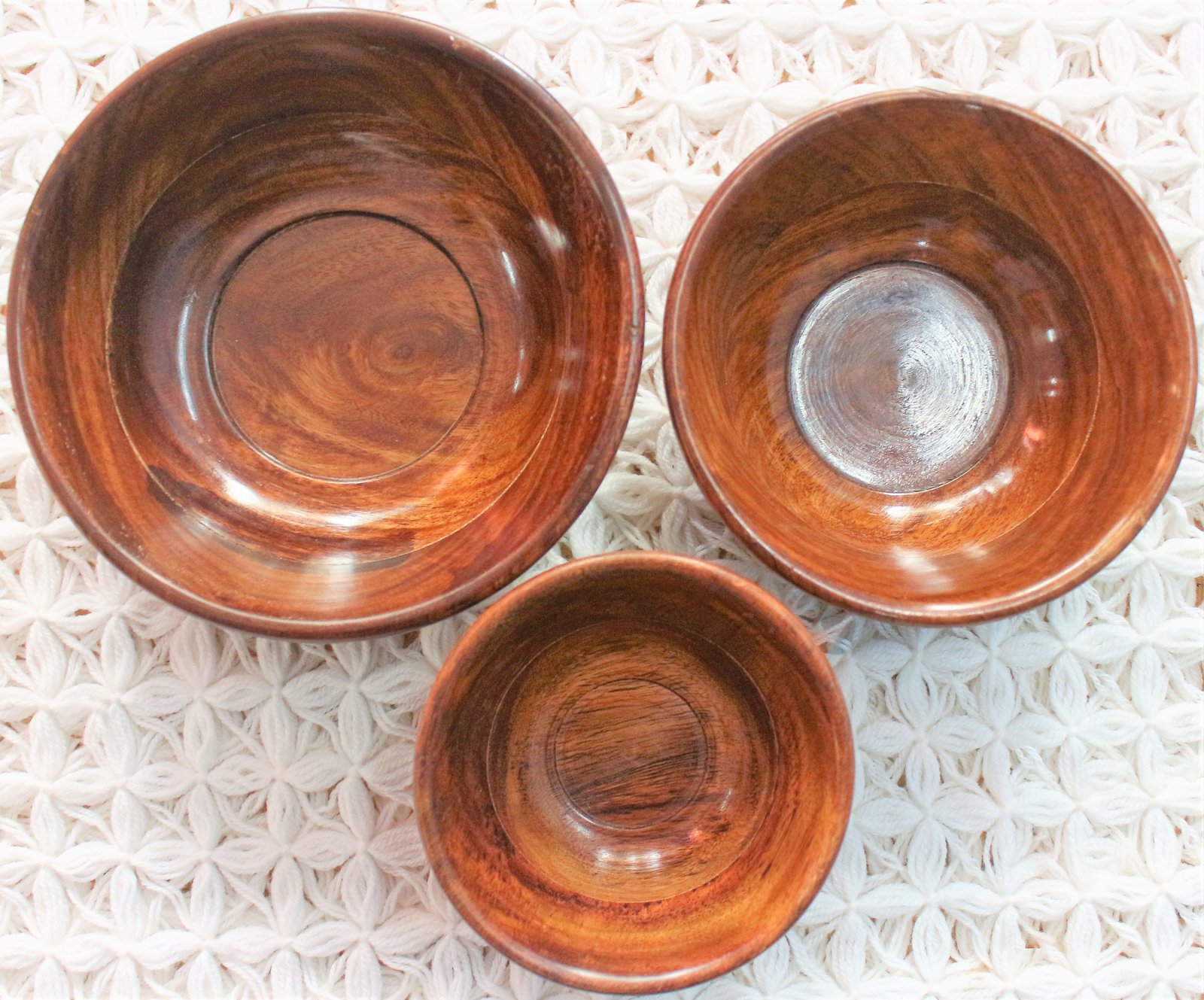 A set of three nested wooden bowls.